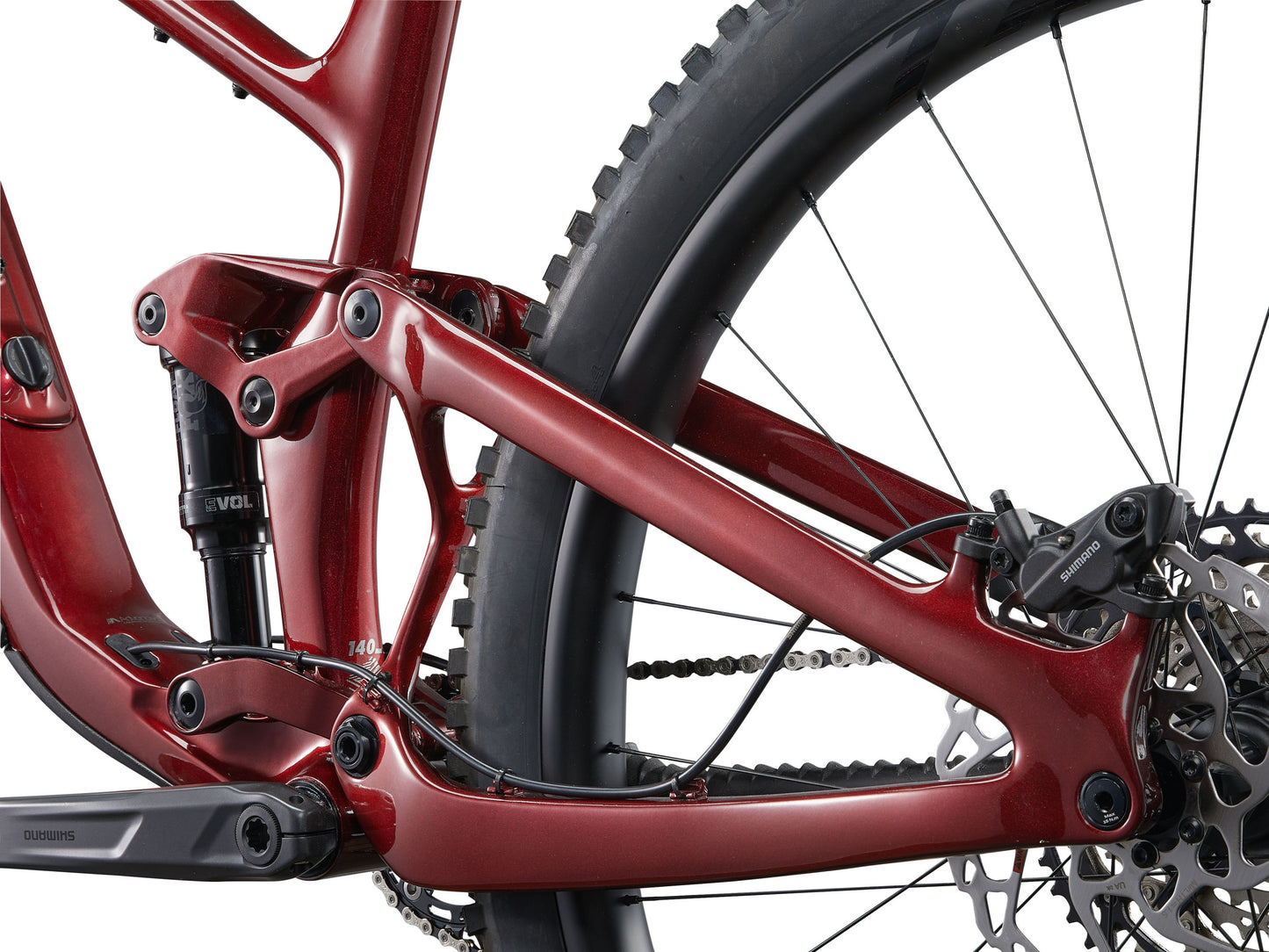 Close-up of a red bicycle frame with chain and wheel on a white background