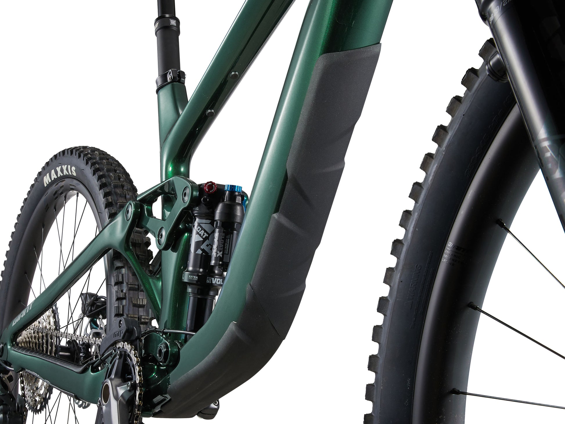 Close-up of a green mountain bike with focus on suspension fork and tire tread.